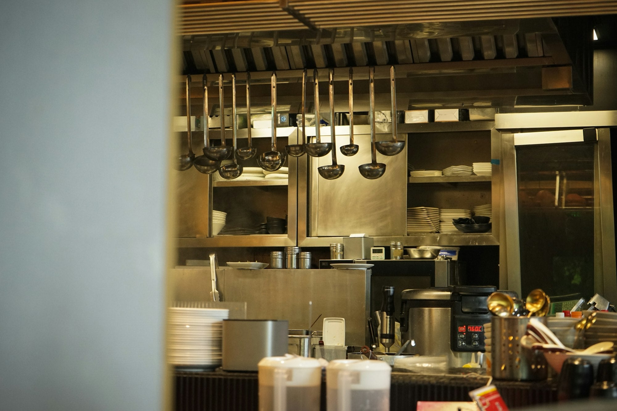 Stainless steel kitchen utensils hanging in a professional kitchen