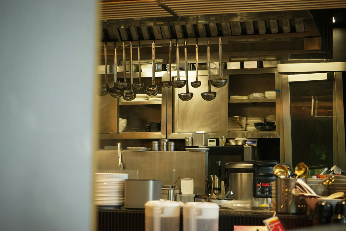 Stainless steel kitchen utensils hanging in a professional kitchen